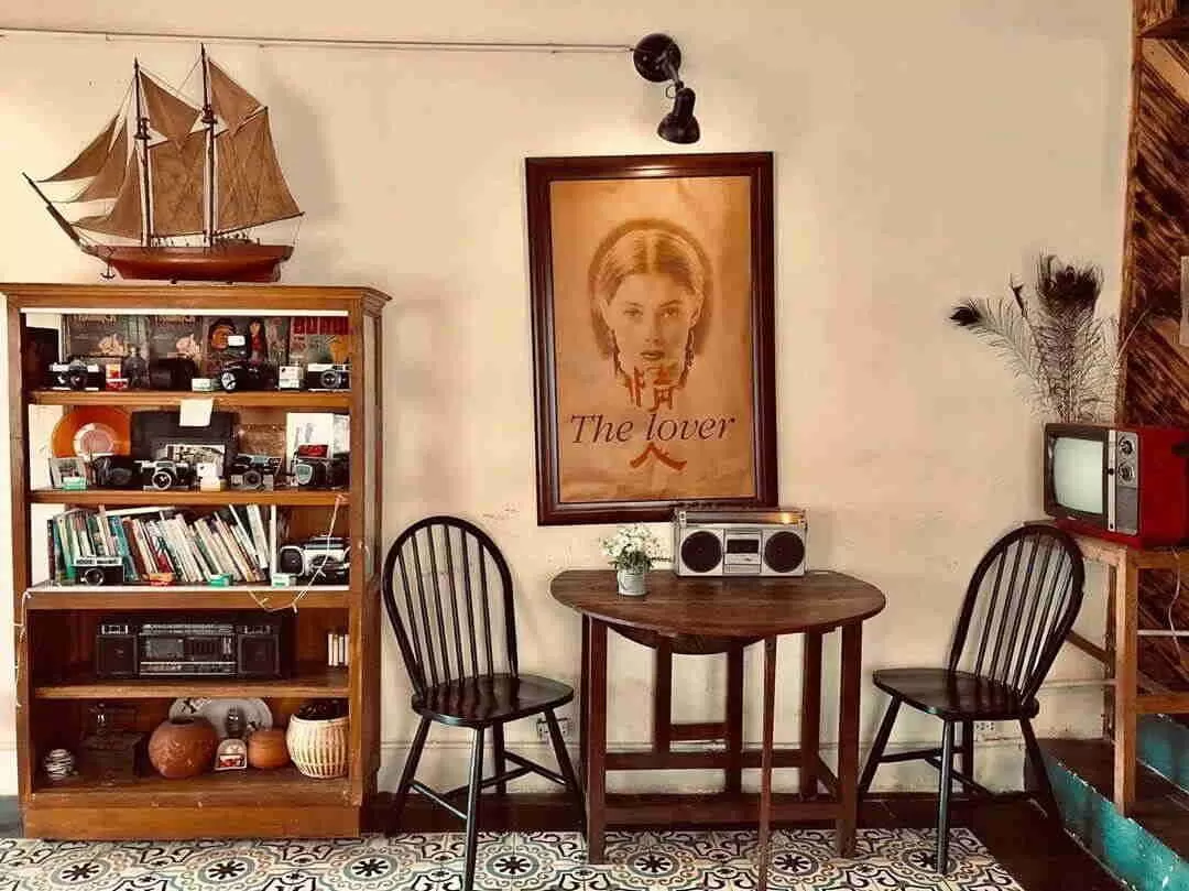 Một góc phòng khách vintage được trang trí bởi những đồ decor lối cũ như đài radio, TV hộp, tranh cũ,...