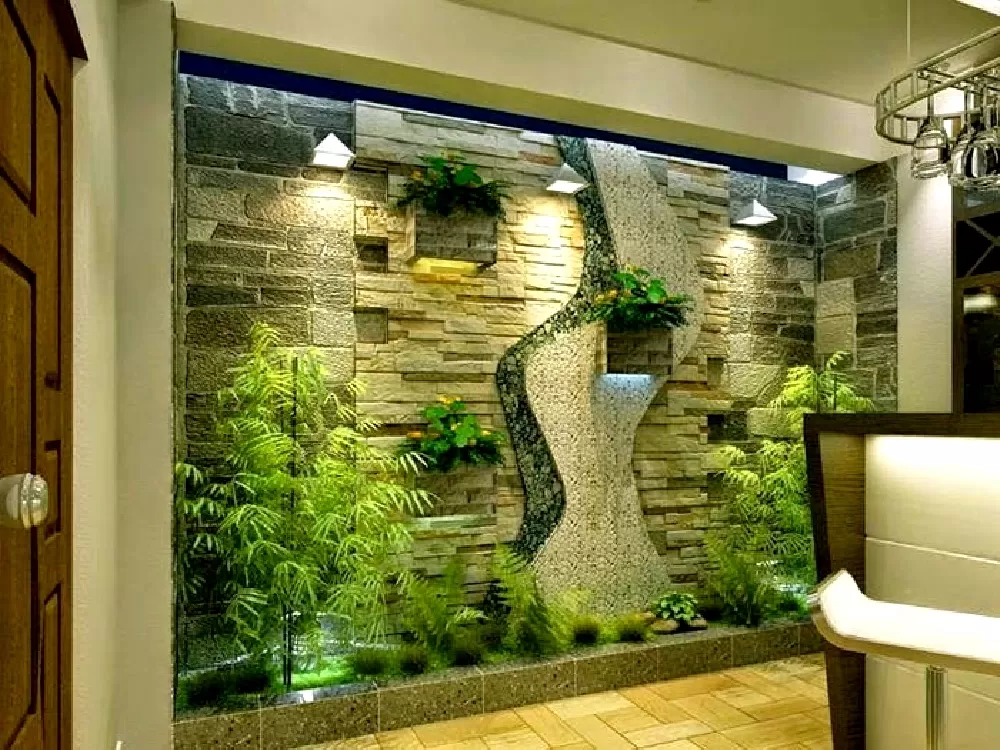 Bức tường được làm bằng đá và có một mảng nước. Cây được sắp xếp theo cách tạo cảm giác bình yên và thư thái.