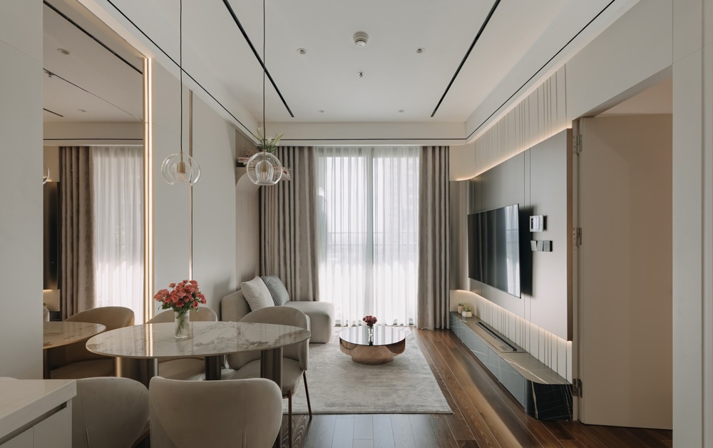 Thiết kế phòng khách liền bếp tại Masteri West Heights sử dụng đảo bếp làm vách ngăn, hệ tủ bếp kịch trần màu trắng, mang lại vẻ đẹp tối giản và sang trọng.