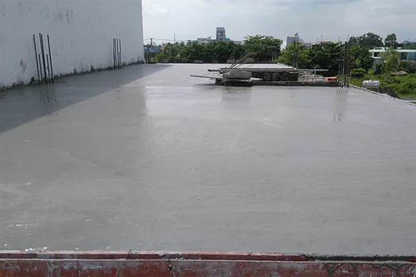 Hình ảnh cận cảnh bề mặt bê tông mái đang được bảo dưỡng bằng cách tưới nước phun sương, thể hiện tầm quan trọng của cách bảo dưỡng bê tông sau khi đổ mái chuẩn kỹ thuật.