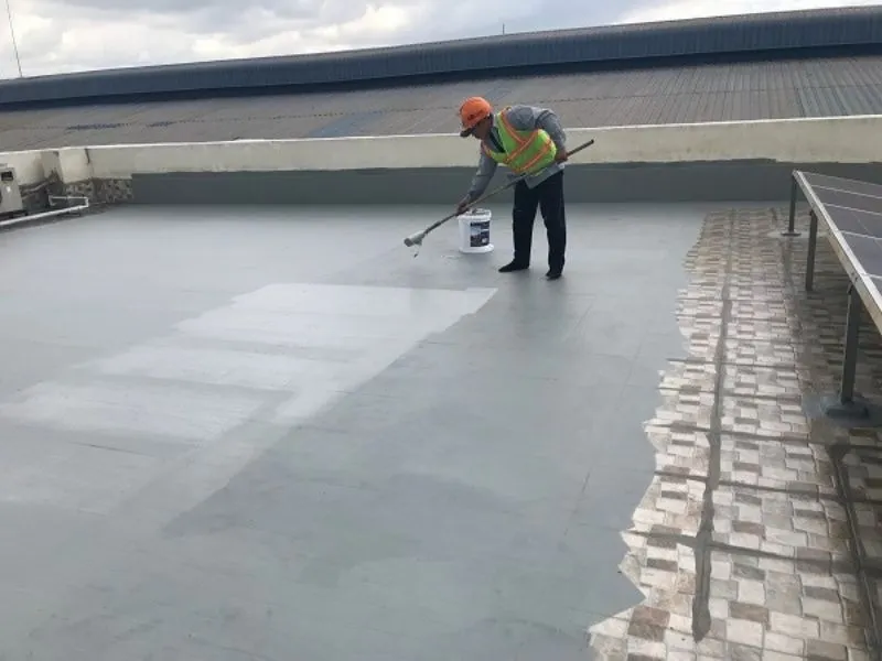 Kỹ thuật viên kiểm tra độ dốc và hoàn thiện chống thấm sân thượng đã lát gạch