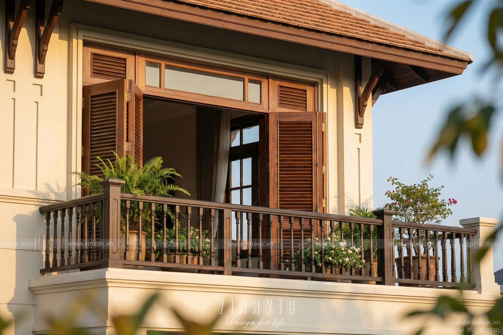 Góc nghiêng biệt thự 2 tầng phong cách Đông Dương phô diễn hệ thống cửa gỗ lá sách và ban công rộng thoáng