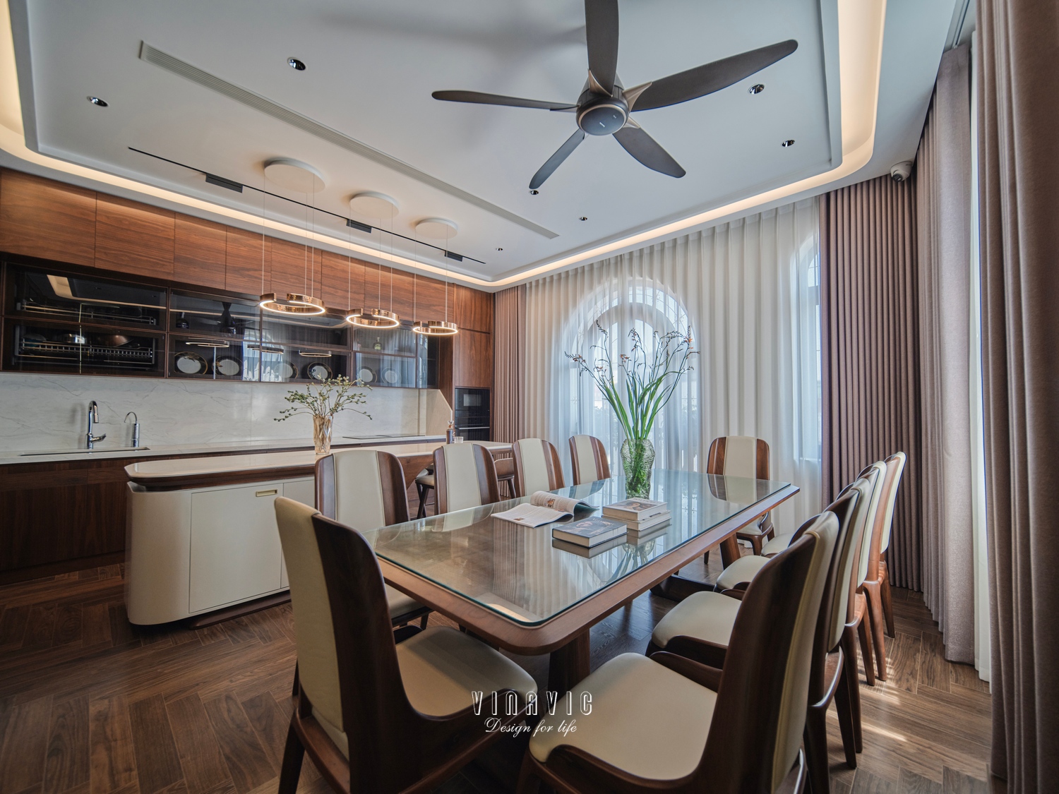 Bố cục mở giữa khu vực bếp và bàn ăn giúp không gian sử dụng linh hoạt hơn, đồng thời tận dụng tối đa ánh sáng tự nhiên từ hệ cửa lớn